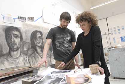 Paint-cheryl student and professor standing over drawings