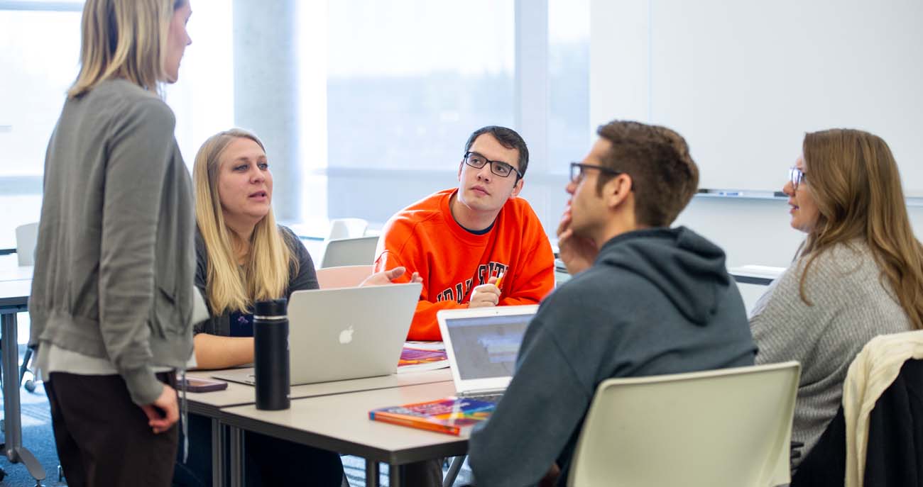 Dr. Warrington talking with students in the classroom