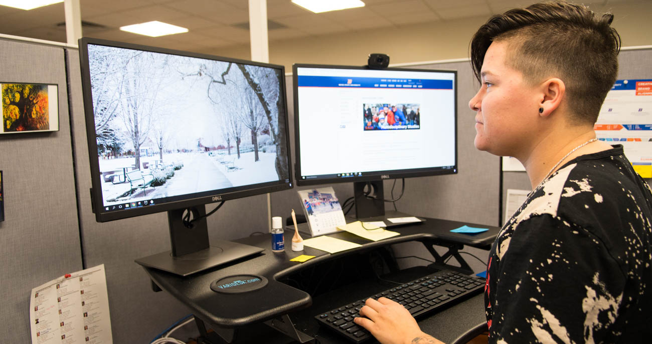 student works between two computer screens